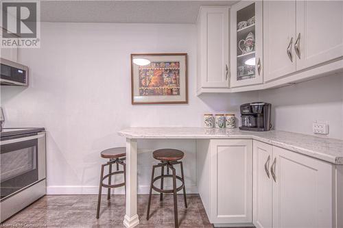 Kitchen featuring light stone countertops, white cabinets, and appliances with stainless steel finishes - 55 Green Valley Drive Drive Unit# 1806, Kitchener, ON - Indoor Photo Showing Other Room