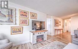 Living room with a textured ceiling and light hardwood / wood-style flooring - 