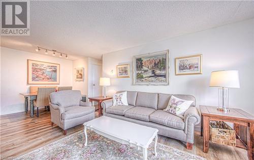 Living room with a textured ceiling and light hardwood / wood-style flooring - 55 Green Valley Drive Drive Unit# 1806, Kitchener, ON - Indoor Photo Showing Living Room