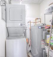 Clothes washing area with water heater and stacked washing maching and dryer - 