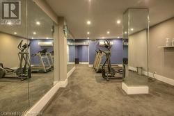 Workout room with carpet flooring and a wall mounted air conditioner - 