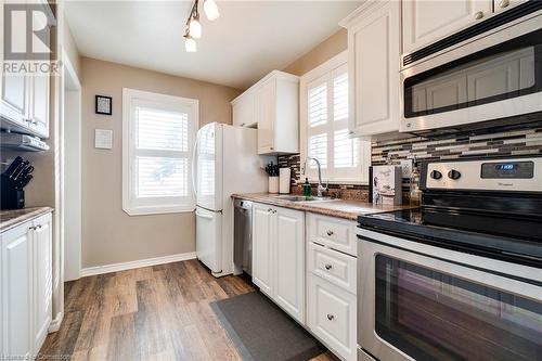 Kitchen featuring white cabinets, sink, stainless steel appliances, and a wealth of natural light - 245 St Andrews Street, Cambridge, ON - Indoor Photo Showing Kitchen With Double Sink