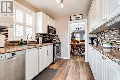 Kitchen featuring decorative backsplash, appliances with stainless steel finishes, light wood-type flooring, and white cabinetry - 245 St Andrews Street, Cambridge, ON - Indoor Photo Showing Kitchen