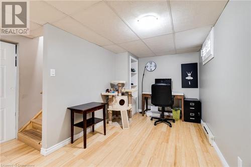 Office area featuring hardwood / wood-style floors, a drop ceiling, and a baseboard heating unit - 245 St Andrews Street, Cambridge, ON - Indoor