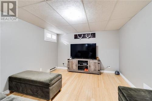 Living room with a paneled ceiling, wood-type flooring, and a baseboard heating unit - 245 St Andrews Street, Cambridge, ON - Indoor