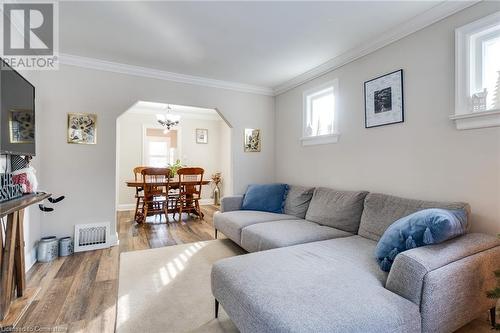 Living room featuring crown molding, an inviting chandelier, and hardwood / wood-style flooring - 245 St Andrews Street, Cambridge, ON - Indoor Photo Showing Living Room