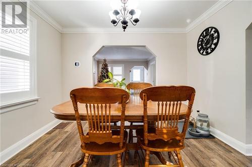 Dining area with hardwood / wood-style flooring, ornamental molding, and a chandelier - 245 St Andrews Street, Cambridge, ON - Indoor Photo Showing Dining Room