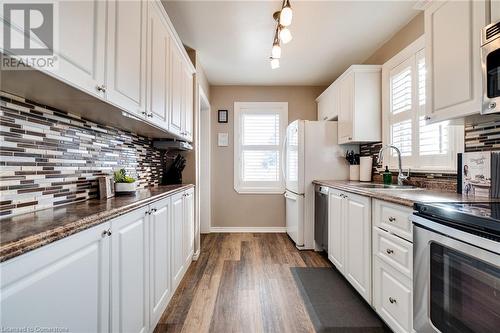 Kitchen featuring sink, dark wood-type flooring, stainless steel appliances, backsplash, and white cabinets - 245 St Andrews Street, Cambridge, ON - Indoor Photo Showing Kitchen