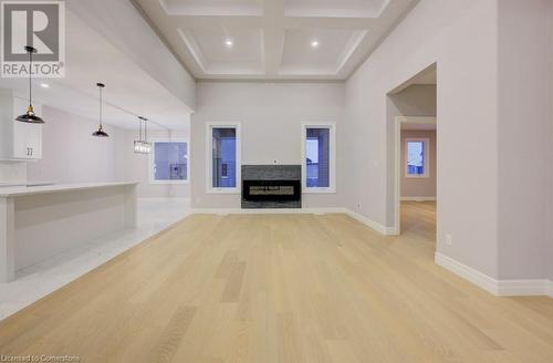 Unfurnished living room featuring beamed ceiling, light wood-type flooring, and coffered ceiling - 705 Hollinger Drive S, Listowel, ON - Indoor Photo Showing Other Room