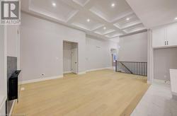 Living room featuring beam ceiling, light wood-type flooring, and coffered ceiling - 