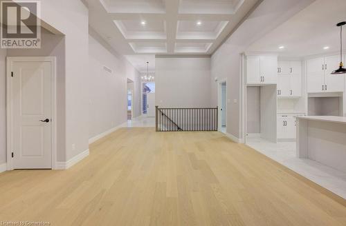 Corridor featuring beamed ceiling, light hardwood / wood-style floors, an inviting chandelier, and coffered ceiling - 705 Hollinger Drive S, Listowel, ON - Indoor