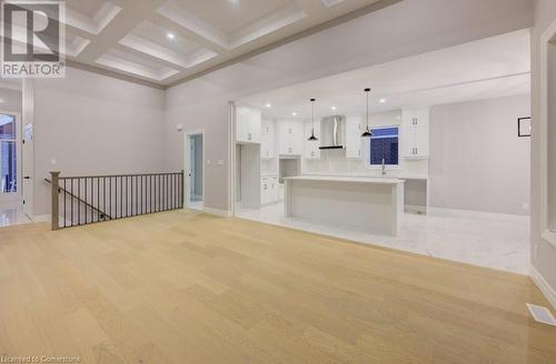 Unfurnished living room featuring beamed ceiling, light hardwood / wood-style floors, coffered ceiling, and ornamental molding - 705 Hollinger Drive S, Listowel, ON - Indoor Photo Showing Other Room