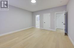 Unfurnished bedroom with light hardwood / wood-style floors and connected bathroom - 