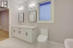 Bathroom with vanity, a tub to relax in, and toilet - 