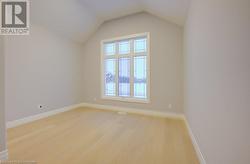 Unfurnished room with light hardwood / wood-style floors and vaulted ceiling - 