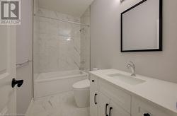 Full bathroom with toilet, vanity, and tiled shower / bath - 