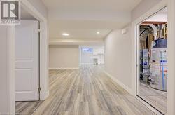 Corridor featuring light hardwood / wood-style flooring and water heater - 