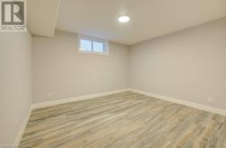 Basement with light hardwood / wood-style flooring - 