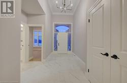 Hallway with ornamental molding and an inviting chandelier - 