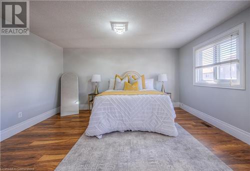 Bedroom with dark hardwood / wood-style floors and a textured ceiling - 83 Bridlewreath Street, Kitchener, ON - Indoor Photo Showing Bedroom