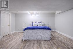 Bedroom with a textured ceiling and hardwood / wood-style flooring - 