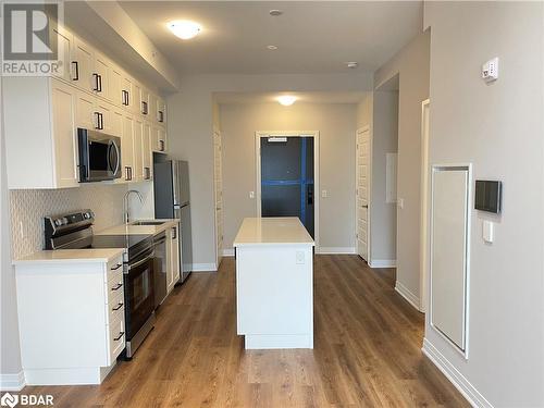 Kitchen featuring appliances with stainless steel finishes, backsplash, sink, hardwood / wood-style floors, and white cabinetry - 490 Gordon Krantz Avenue Unit# 602, Milton, ON - Indoor Photo Showing Kitchen