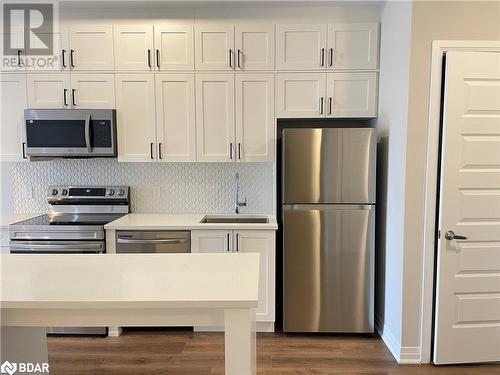 Kitchen featuring sink, stainless steel appliances, dark hardwood / wood-style floors, backsplash, and white cabinets - 490 Gordon Krantz Avenue Unit# 602, Milton, ON - Indoor Photo Showing Kitchen With Stainless Steel Kitchen