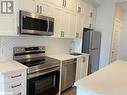 Kitchen with white cabinetry, sink, appliances with stainless steel finishes, and tasteful backsplash - 490 Gordon Krantz Avenue Unit# 602, Milton, ON  - Indoor Photo Showing Kitchen With Stainless Steel Kitchen 