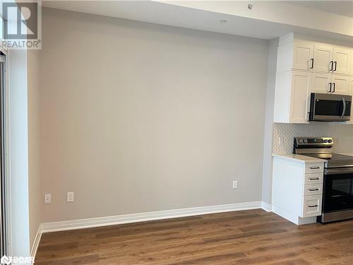 Kitchen featuring stainless steel appliances, white cabinetry, tasteful backsplash, and dark wood-type flooring - 490 Gordon Krantz Avenue Unit# 602, Milton, ON - Indoor Photo Showing Kitchen