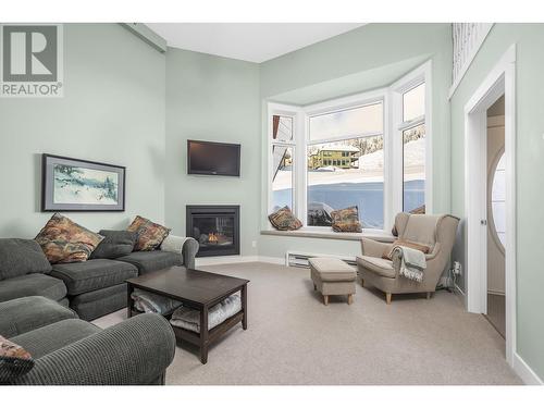 Family gathering - 9885 Pinnacles Road Unit# 21, Vernon, BC - Indoor Photo Showing Living Room With Fireplace