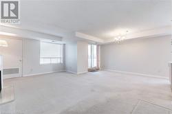 Spare room with a textured ceiling, light carpet, and a chandelier - 