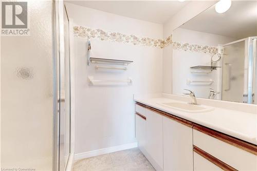 Bathroom featuring tile patterned flooring, vanity, and a shower with shower door - 870 Upper Wentworth Street Unit# 202, Hamilton, ON - Indoor Photo Showing Bathroom