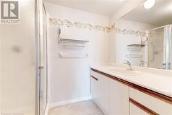 Bathroom featuring tile patterned flooring, vanity, and a shower with shower door - 