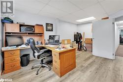 Office with light hardwood / wood-style flooring and a drop ceiling - 