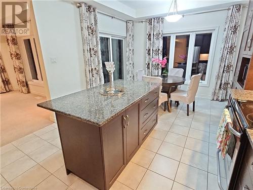 Kitchen with range, a center island, decorative light fixtures, and light stone counters - 218 Gravel Ridge Trail, Kitchener, ON - Indoor