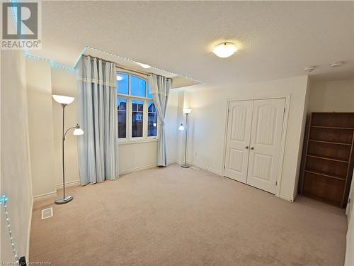 Carpeted empty room featuring a textured ceiling - 218 Gravel Ridge Trail, Kitchener, ON - Indoor Photo Showing Other Room