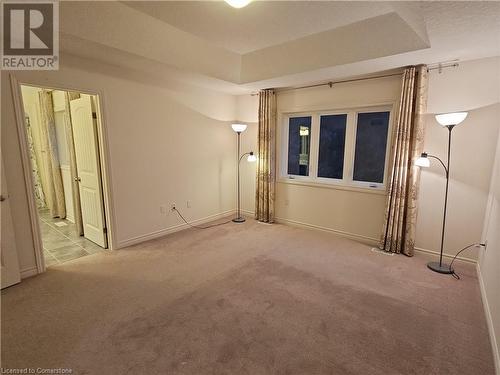 Spare room with light carpet and a tray ceiling - 218 Gravel Ridge Trail, Kitchener, ON - Indoor Photo Showing Other Room