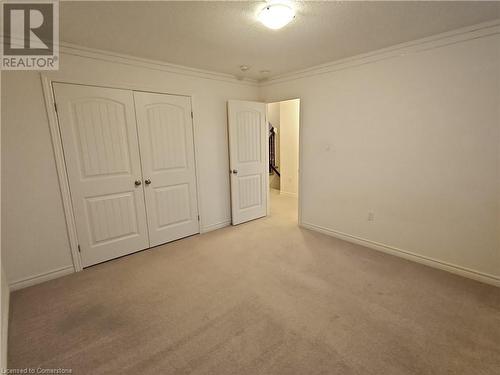 Unfurnished bedroom with light colored carpet, crown molding, and a closet - 218 Gravel Ridge Trail, Kitchener, ON - Indoor Photo Showing Other Room