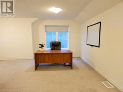 Carpeted office space featuring lofted ceiling - 