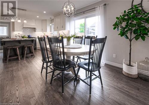 Dining area with dark hardwood / wood-style flooring and an inviting chandelier - 66 Lock Street, Innerkip, ON - Indoor Photo Showing Dining Room