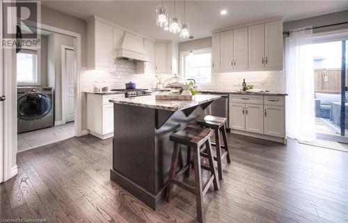 Kitchen featuring white cabinets, washer / clothes dryer, a kitchen island, and premium range hood - 66 Lock Street, Innerkip, ON - Indoor Photo Showing Kitchen With Upgraded Kitchen