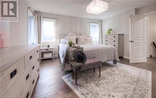 Bedroom with dark wood-type flooring and an inviting chandelier - 66 Lock Street, Innerkip, ON - Indoor Photo Showing Bedroom