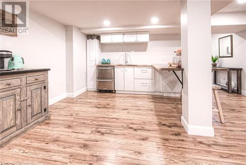 Bar featuring white cabinets, sink, and light hardwood / wood-style flooring - 66 Lock Street, Innerkip, ON - Indoor Photo Showing Kitchen