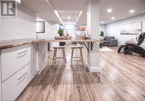 Kitchen with a breakfast bar, kitchen peninsula, hardwood / wood-style flooring, and white cabinets - 66 Lock Street, Innerkip, ON - Indoor