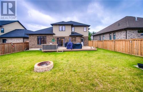 Rear view of property with a lawn, an outdoor fire pit, and a wooden deck - 66 Lock Street, Innerkip, ON - Outdoor With Backyard With Exterior