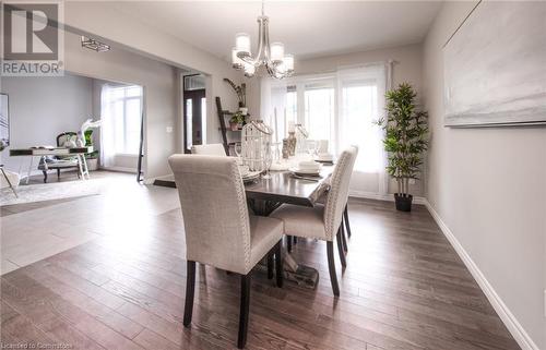 Dining area featuring a wealth of natural light, dark hardwood / wood-style flooring, and a notable chandelier - 66 Lock Street, Innerkip, ON - Indoor Photo Showing Dining Room