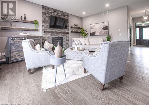 Living room featuring a stone fireplace and light hardwood / wood-style floors - 66 Lock Street, Innerkip, ON - Indoor Photo Showing Living Room With Fireplace