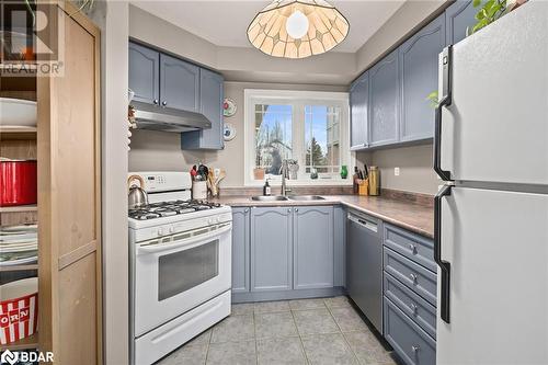 Kitchen featuring light tile patterned flooring, white appliances, and sink - 17 Emslie Street, Halton, ON - Indoor Photo Showing Kitchen With Double Sink