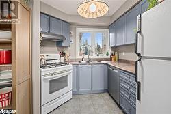 Kitchen featuring light tile patterned flooring, white appliances, and sink - 