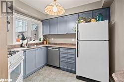 Kitchen featuring pendant lighting, white appliances, sink, and light tile patterned floors - 